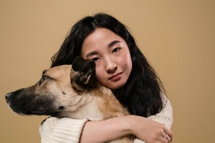 spot-pain-in-cats-dgs-rabbits female holding large brown dog