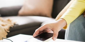 Mobile phone being placed on a charger on a coffee table