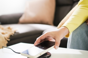 Mobile phone being placed on a charger on a coffee table